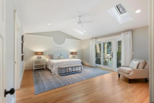 a white bedroom with a bed and a chair at 335 Winged Foot in Kiawah Island