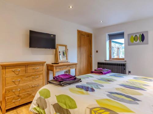 a bedroom with a bed and a tv on the wall at 3 bed in Fowey 53664 in Warleggan