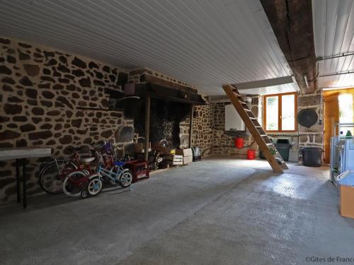 a room with a stone wall with motorcycles parked in it at Maison de charme avec jardin, nature, cheminée, WiFi, proche manoirs et rivières tortueuses - FR-1-497-99 in Saint-Bômer-les-Forges