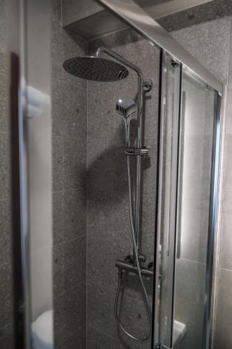 a shower with a shower head in a bathroom at S Apart Rooms in Bosanska Gradiška