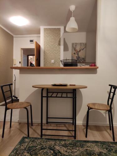 a dining room with a table and two chairs at Apartament Widokowo in Sopot