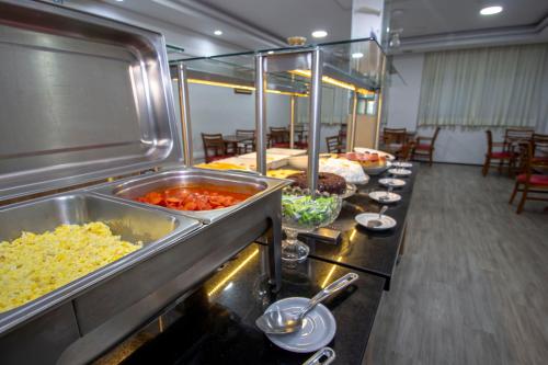 uma linha de buffet com muitos tipos diferentes de alimentos em Hotel Golden Park Curitiba em Curitiba