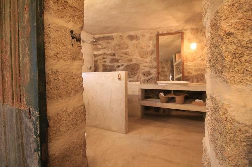 a stone bathroom with a sink and a refrigerator at Villa Cornelia, Ponte de Lima in Ponte de Lima