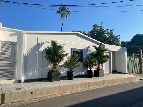 un edificio blanco con palmeras delante en Deko rooms en Arauca
