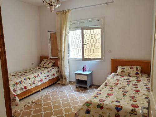 a bedroom with two beds and a window at Omnia House in Monastir