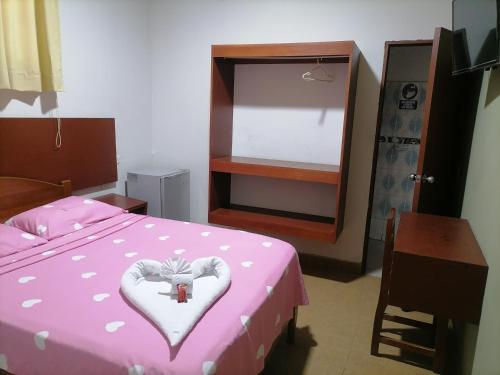 a bedroom with a pink bed with a heart on it at Hostal Camu Camu in Iquitos