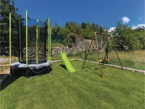 two swings in a yard with grass at Poolside Paradise in Srijane