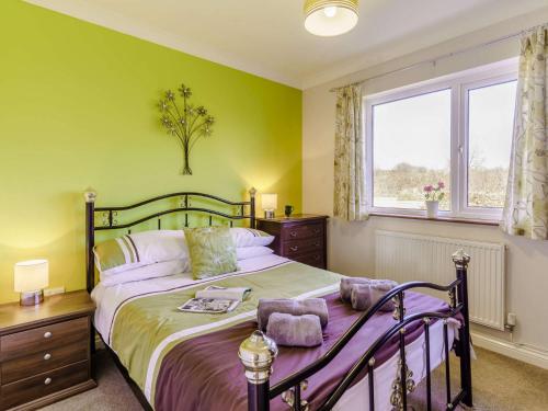 - une chambre avec un lit aux murs verts et une fenêtre dans l'établissement 3 Bed in Narberth 73936, à Maenclochog