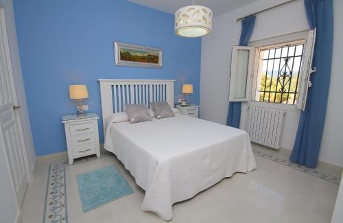 ウブリケにあるCasa Rural Veinte Pilaresの青いベッドルーム(ベッド1台、窓付)
