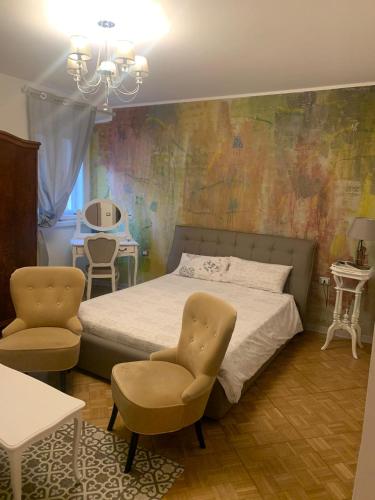 um quarto com uma cama e 2 cadeiras em THE FIRST em Trieste