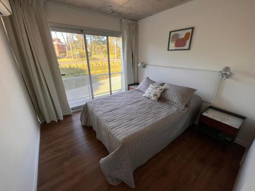 a bedroom with a bed and a large window at Edificio Pinheiros in Punta del Este