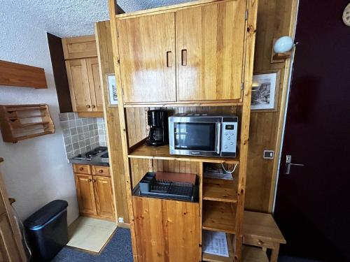 une petite cuisine avec un four micro-ondes sur une étagère dans l'établissement Studio Économique 13m² pour 2 personnes au pied des pistes, Croisette, Les Menuires - FR-1-452-285, aux Menuires