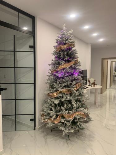 a christmas tree in a room next to a door at ΟΙΚΙΑ ΑΠΟΖΑΡΙ ΜΕΓΑΛΗ ΠΕΡΣΑ in Kastoria