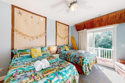 1 dormitorio con 2 camas y ventana en All Decked Out en Ocean Isle Beach