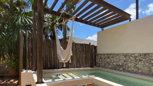 a swimming pool with a hammock in a backyard at Art 57 Hotel - Adults Only in Mérida
