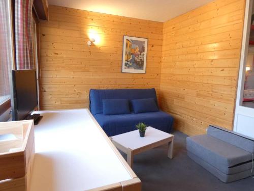 a living room with a blue couch and a table at Charmant studio à 1er étage, 4 pers., balcon, salle fitness, park, ski, jacuzzi - St Lary Soulan - FR-1-457-252 in Vignec