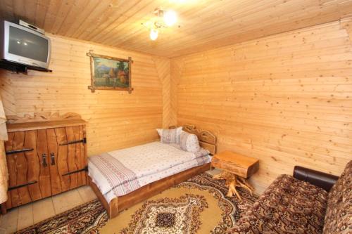 um quarto com uma cama e uma televisão numa cabina em Садиба "Svitlana" em Yablunytsya