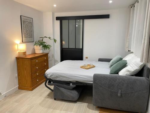 - une chambre avec un lit, un canapé et une commode dans l'établissement Le studio d'Arry, à Le Locheur