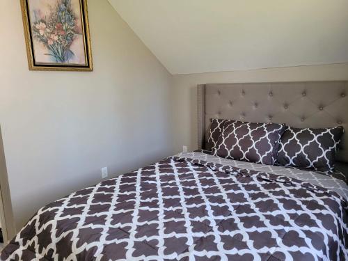 a bedroom with a bed with a black and white comforter at Big new house with huge parking in West Seneca