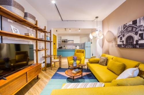 a living room with a yellow couch and a tv at Casa Miravalle in Mexico City