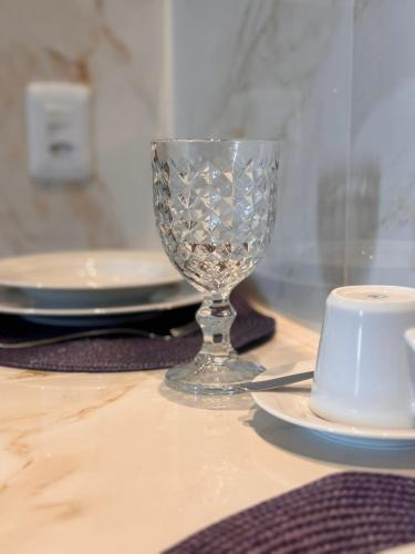 a glass wine glass sitting on top of a table at Flat localizado a 200m Shopping Recife, bem Perto da Praia de Boa Viagem e com Wi-Fi 400Mbps in Recife
