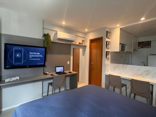 a room with a bed and a desk with a tv at Flat localizado a 200m Shopping Recife, bem Perto da Praia de Boa Viagem e com Wi-Fi 400Mbps in Recife