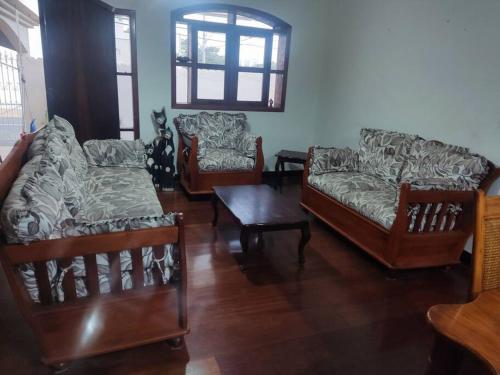 a living room with two couches and a table at Casa rústica Jardim Abaete in Piracicaba