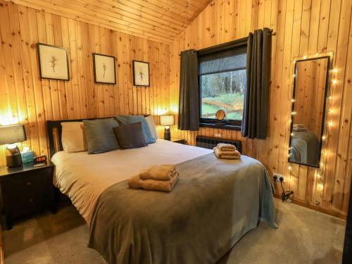 a bedroom with a bed with two towels on it at Newsham Lodge in Penrith