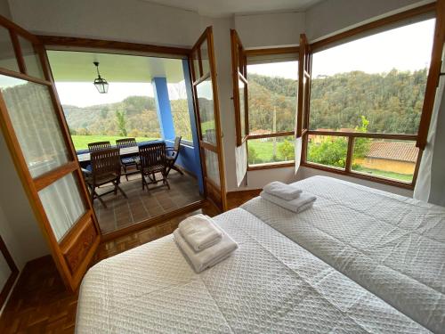 1 dormitorio con 2 camas y comedor con mesa en VILLA ACEBO, en Arboleya