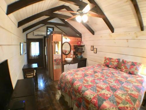 um quarto com uma cama e uma ventoinha de tecto em Tiny Home Cottage Near the Smokies #11 Mina em Sevierville