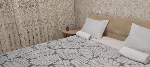 um quarto com uma cama com lençóis brancos e almofadas em бульвар Олександрійський 137 Comfort house em Bila Tserkva