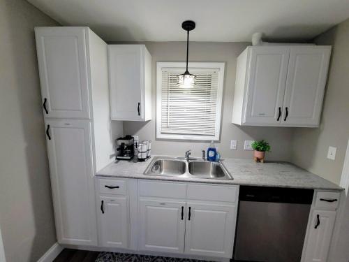 a kitchen with white cabinets and a sink at Big new house with huge parking in West Seneca