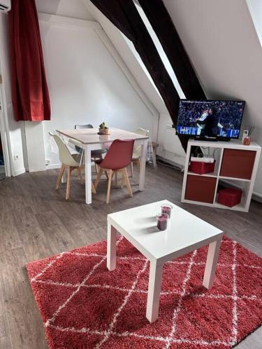 - un salon avec une table blanche et un tapis rouge dans l'établissement Le Saint Eusèbe, à Auxerre