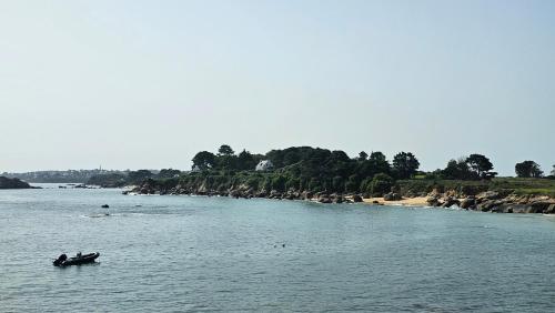 deux personnes sont dans un bateau dans l'eau dans l'établissement Ker Douara - Île Callot, à Carantec
