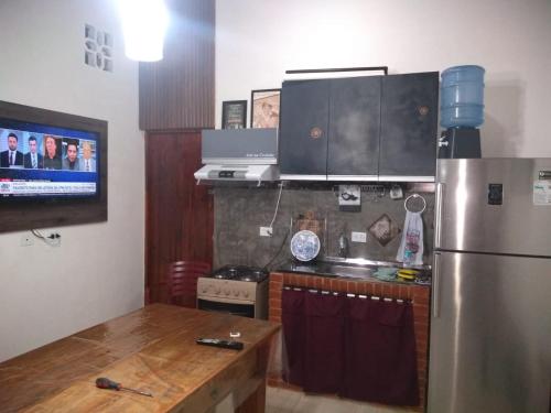 a kitchen with a stainless steel refrigerator and a table at Chalé Sol de Primavera in Arujá