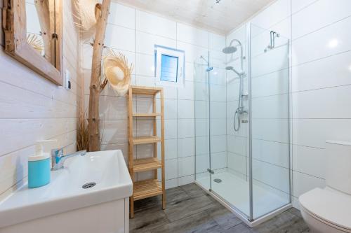 a bathroom with a shower and a sink and a toilet at Domki Dzika Plaża in Dąbki