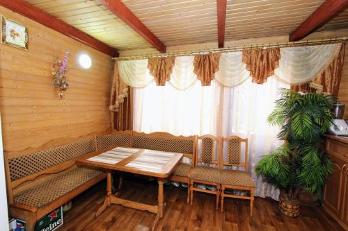 uma sala de jantar com uma mesa e cadeiras e uma janela em Садиба "Svitlana" em Yablunytsya