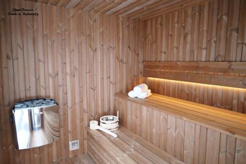 um camarote com paredes com painéis de madeira e piso de madeira em SzumiPuszcza - domki, sauna, jacuzzi em Białowieża