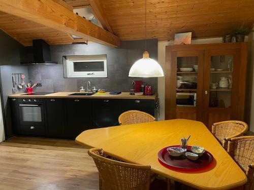 a kitchen with a wooden table with chairs and a dining room at The Old Barn in Hoevelaken