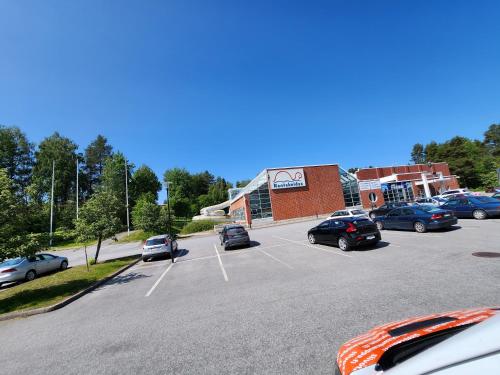 a parking lot with cars parked in front of a building at Valoisa huoneisto jossa erinomaiset vuoteet. in Mikkeli