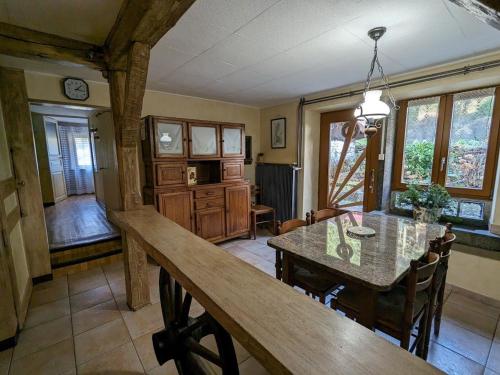 une cuisine et une salle à manger avec une table et des chaises dans l'établissement Gîte chaleureux en pleine nature avec terrasse, idéal pour randonnées et vététistes, proche de Gérardmer - FR-1-589-125, à Le Syndicat