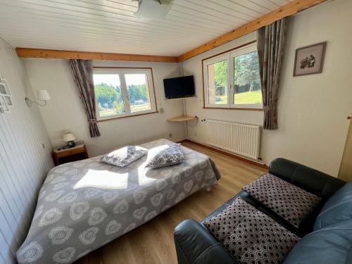 a small bedroom with a bed and a couch at Gîte confortable à Gérardmer avec jardin, ski, randonnées et activités nautiques - FR-1-589-128 in Gérardmer