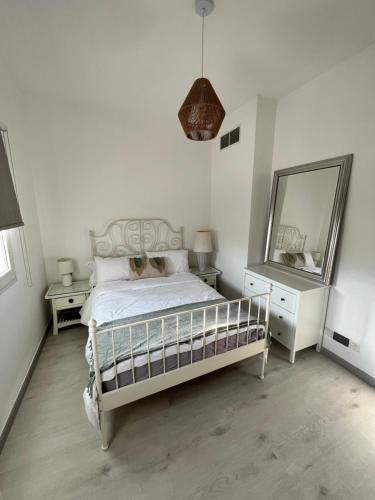 a white bedroom with a bed and a mirror at Charming villa w/ private garden in Dubai