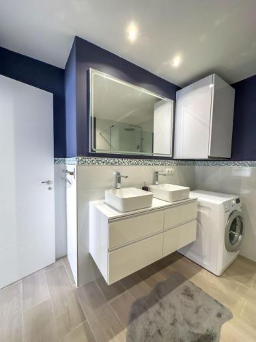 a bathroom with two sinks and a washing machine at Secret View Elviria in Marbella