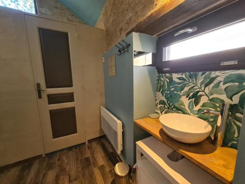 a bathroom with a sink on a counter with a window at Maison avec jardin, piscine chauffée et baignade à proximité - Le Menoux - FR-1-591-234 in Le Menoux
