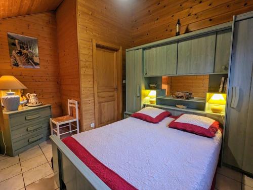 a bedroom with a large bed in a wooden room at Chalet confortable à Cleurie avec WIFI, cheminée et terrasse - FR-1-589-71 in Cleurie