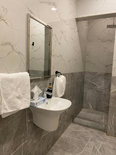 La salle de bains est pourvue d'un lavabo et d'une douche. dans l'établissement 4Beds Condo front the Boulevard, à Riyad