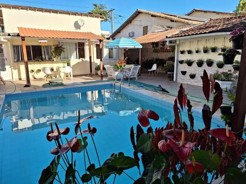 a swimming pool in front of a house at Cantinho da Paz in Niterói