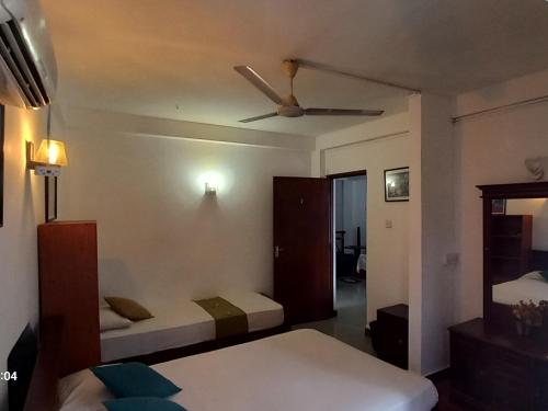 a bedroom with two beds and a ceiling fan at Days Inn B/B in Kandy