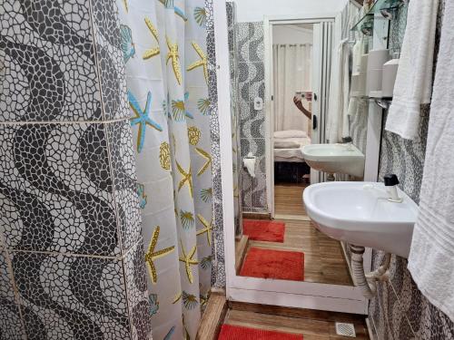 uma casa de banho com um lavatório e um espelho em Cantinho da Paz em Niterói